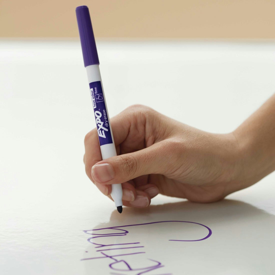 Écrivez sur un tableau blanc avec un marqueur violet à pointe fine.